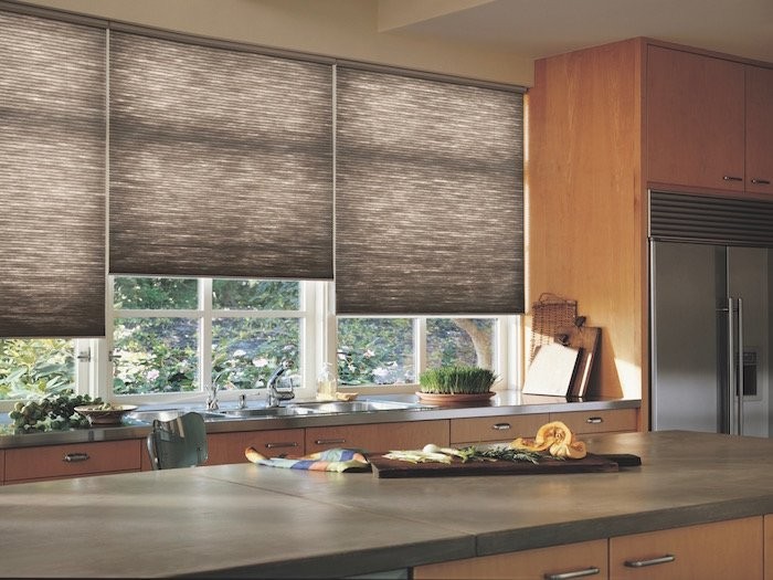 Kitchen with cement counters and brown Duette shades in the window